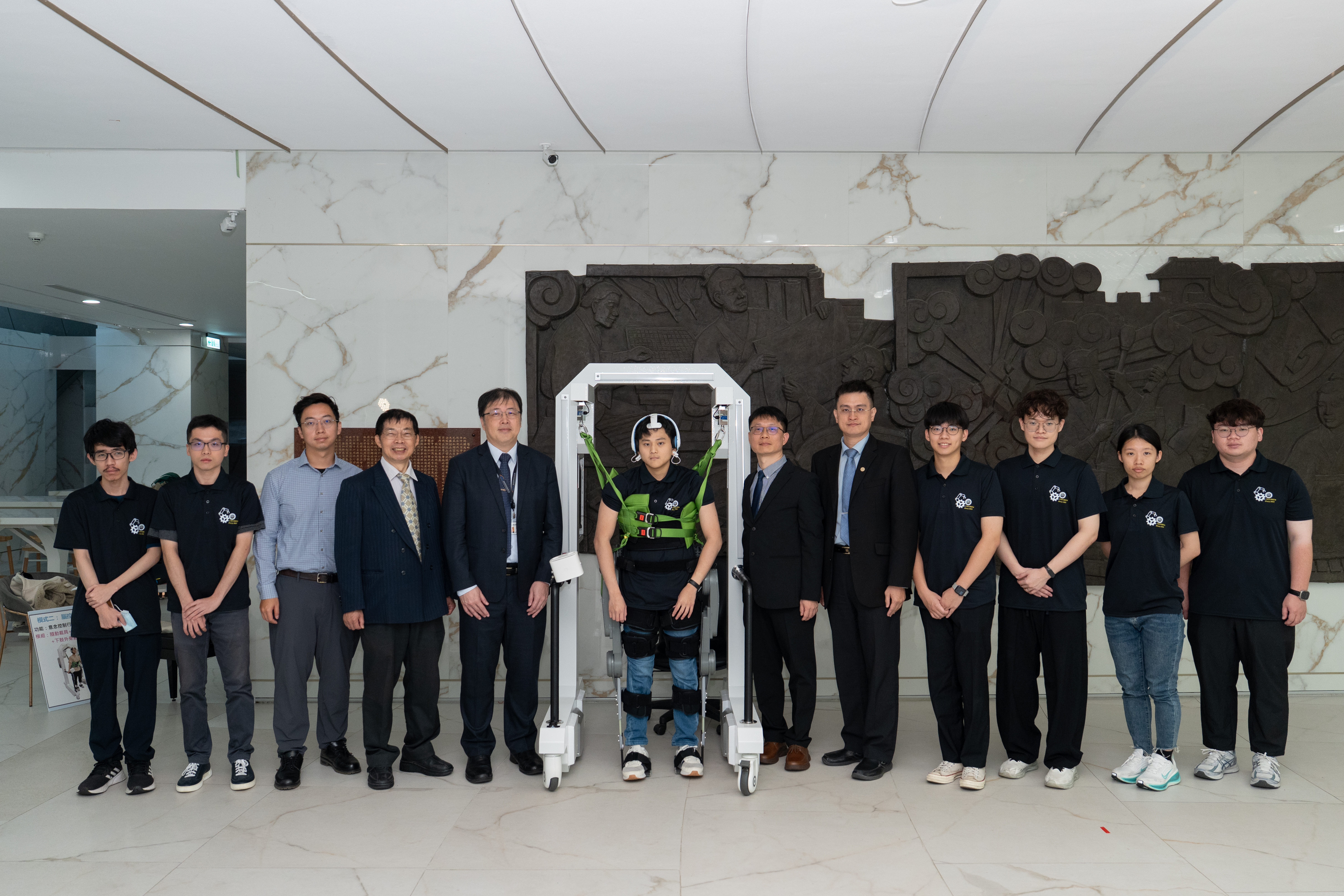 在國科會長期支持下，國立中興大學李聯旺優聘副教授組成跨領域團隊，歷經10年打造全球首創的「AI隨動步行復健機器人(HopeStride)」。左3為高雄醫學大學附設中和紀念醫院復健部陳治廷醫師、左4為高雄醫學大學學士後醫學系陳嘉炘教授、左5為工程處洪樂文處長、左7為國立中興大學機械系李聯旺優聘副教授、左8為國立陽明交通大學電控工程研究所柯立偉教授